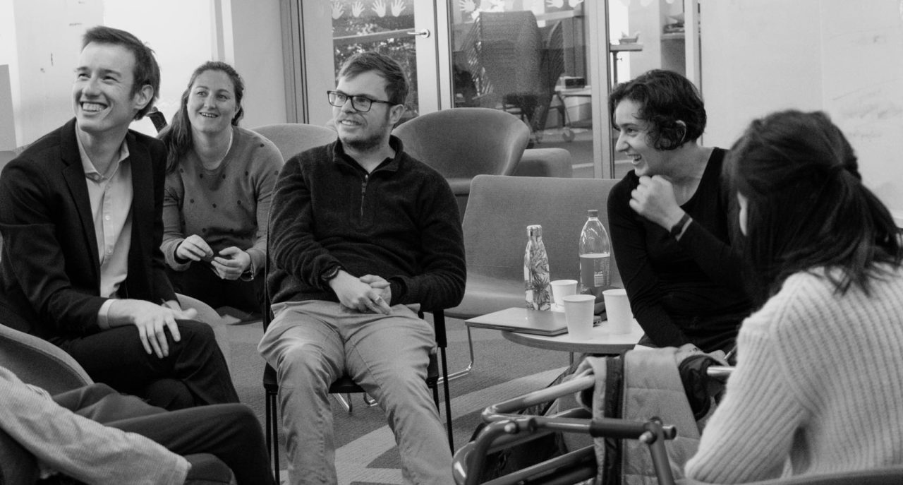 Young people casually chatting around small table